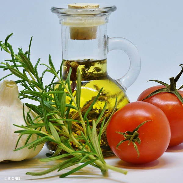 Glasflasche mit Olivenöl , Tomate und Rosmarin